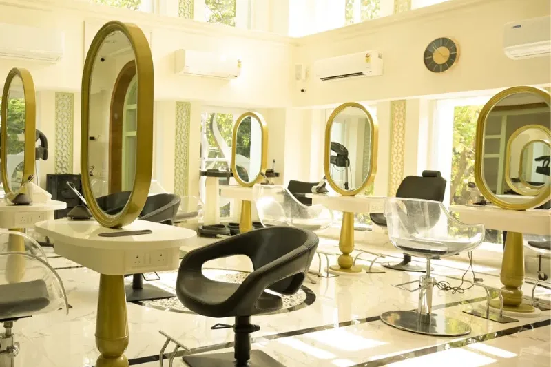 Salon interior with styling chairs and gold-framed mirrors