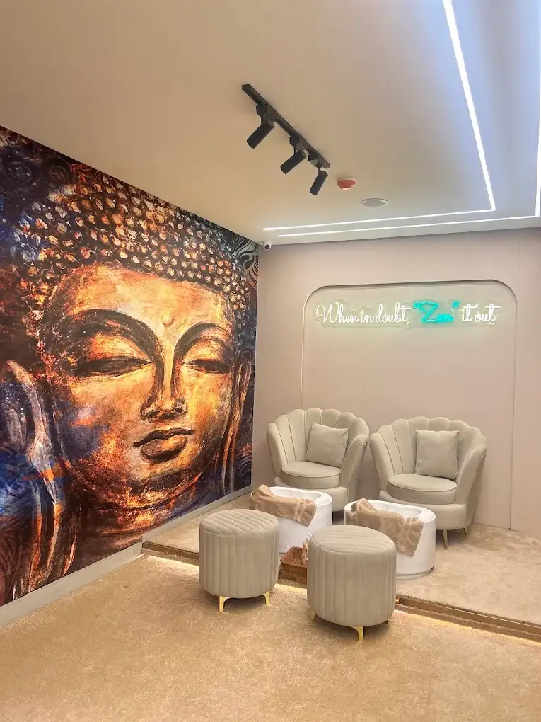 Lounge seating with armchairs, ottomans and a large Buddha mural at Modern Zen Spa
