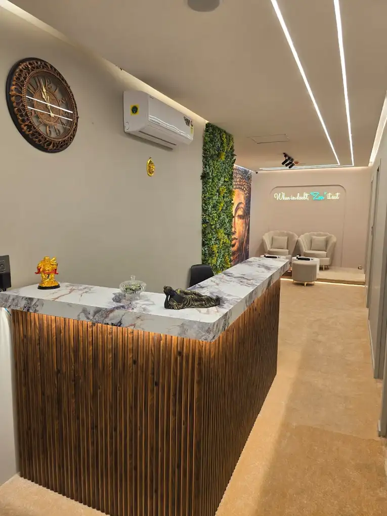 Wood-panelled reception desk with a marble counter inside Modern Zen Spa